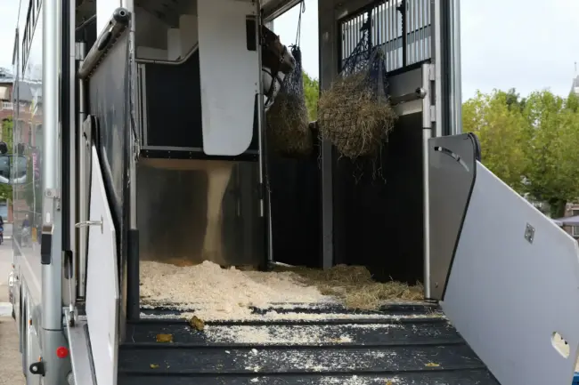 a horse trailer with hay inside of it