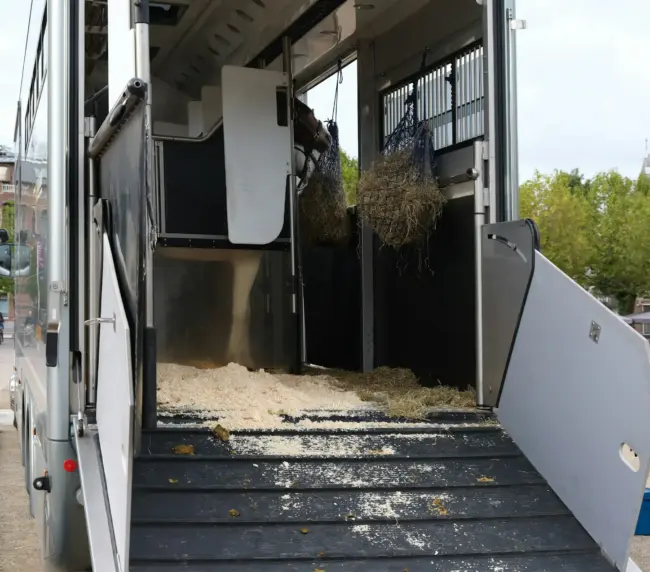a horse trailer with hay inside of it